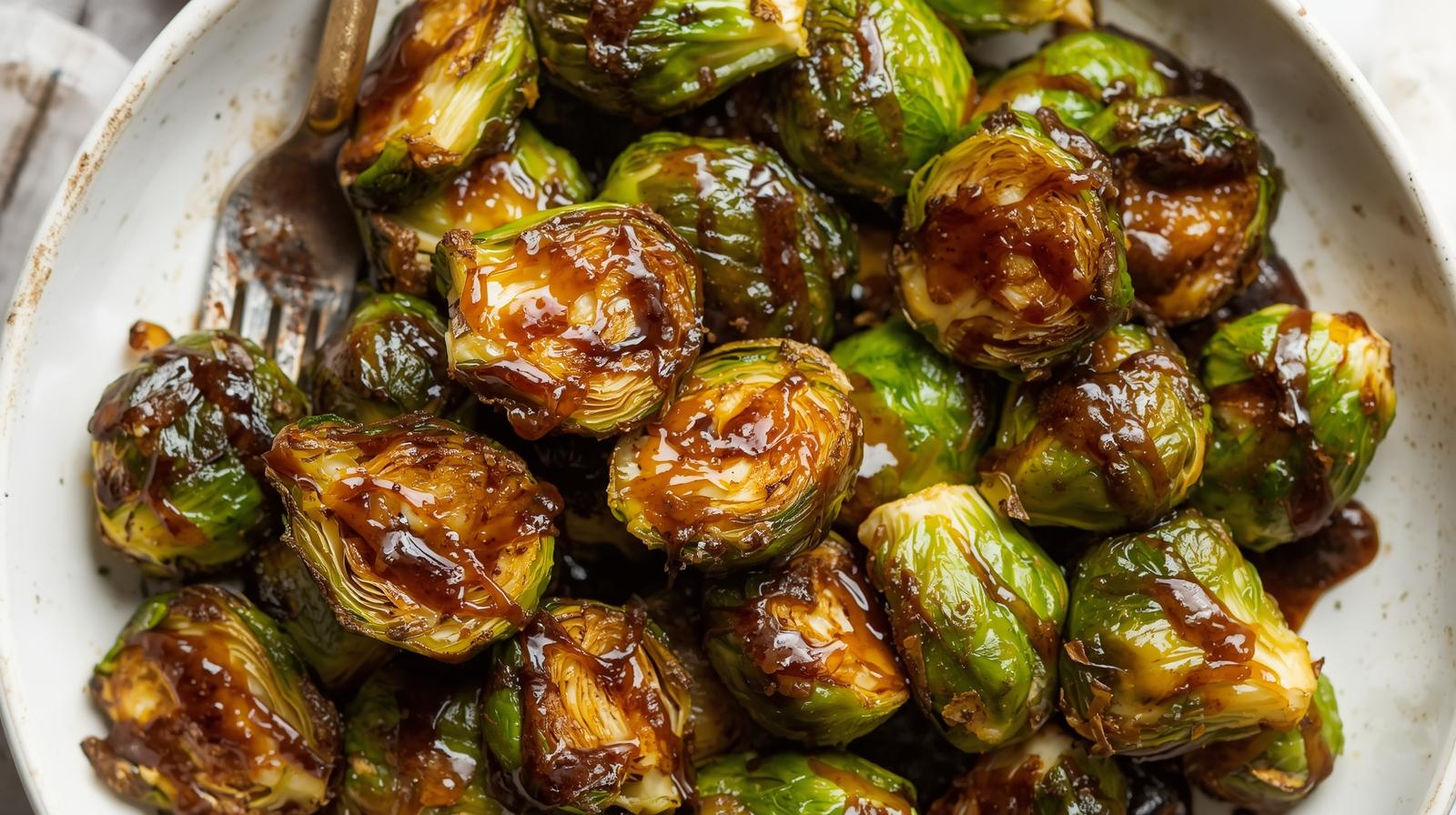 A bowl of perfectly crispy roasted Brussels sprouts with a shiny balsamic glaze.